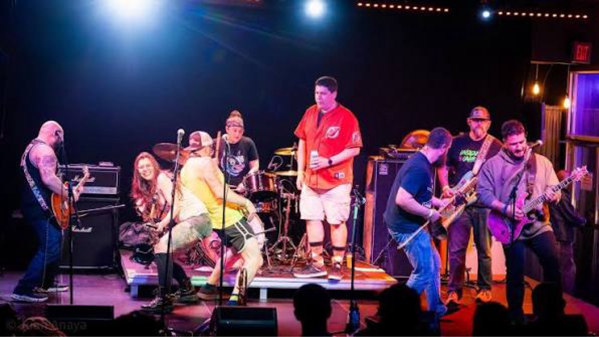 Backyard Superheroes live on stage — the full band performing under bright stage lights