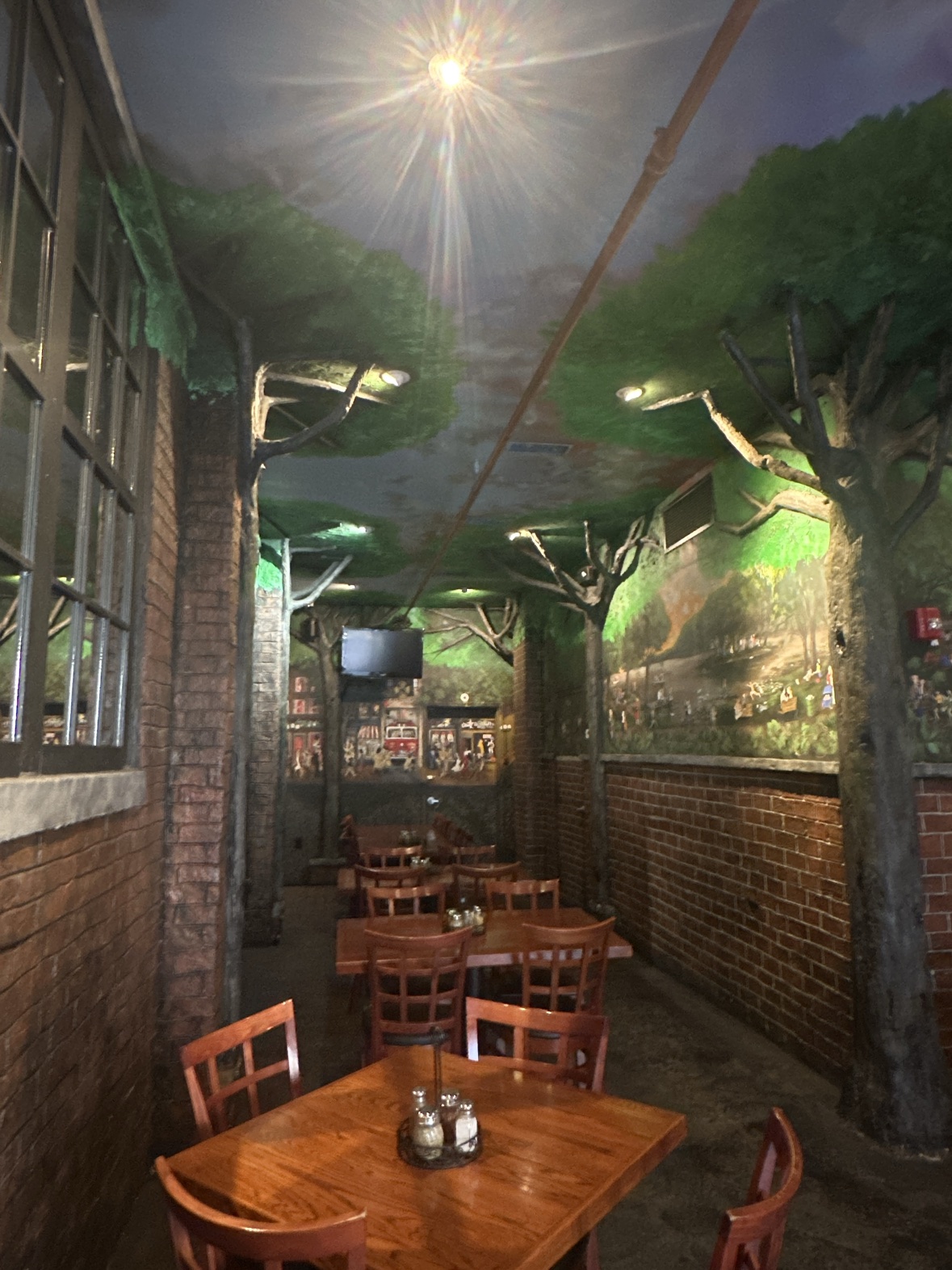 The Ferraro's dining room, where tree trunks rise from the floor and spread into a green painted canopy overhead