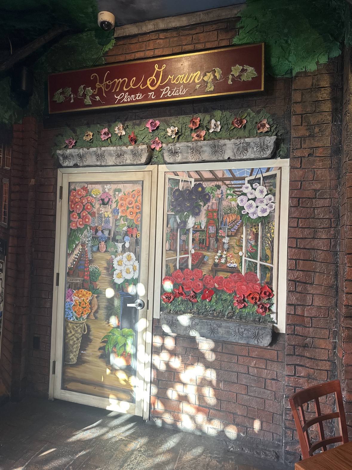 A painted flower-shop door and window inside Ferraro's, under a sign reading 'Home Grown, Plants n Petals'