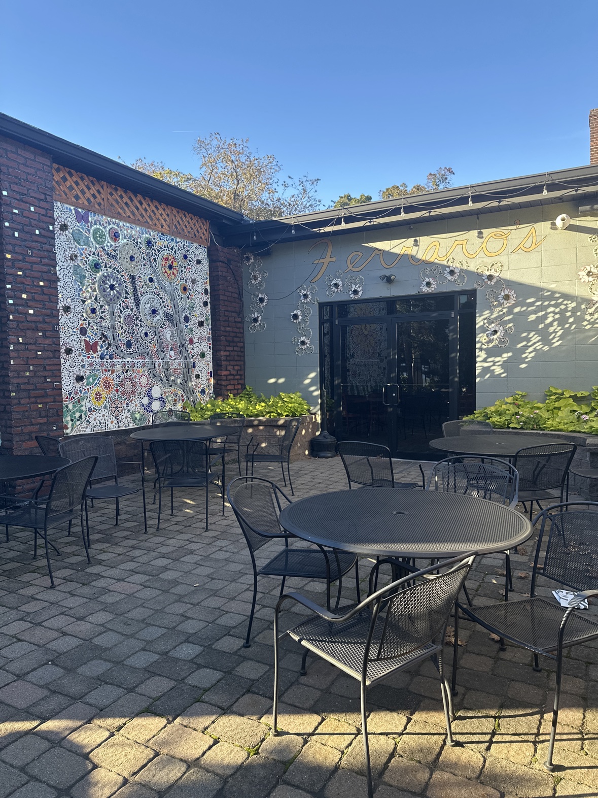 The patio entrance at Ferraro's, with tables out front and the restaurant's name in gold script above the doors