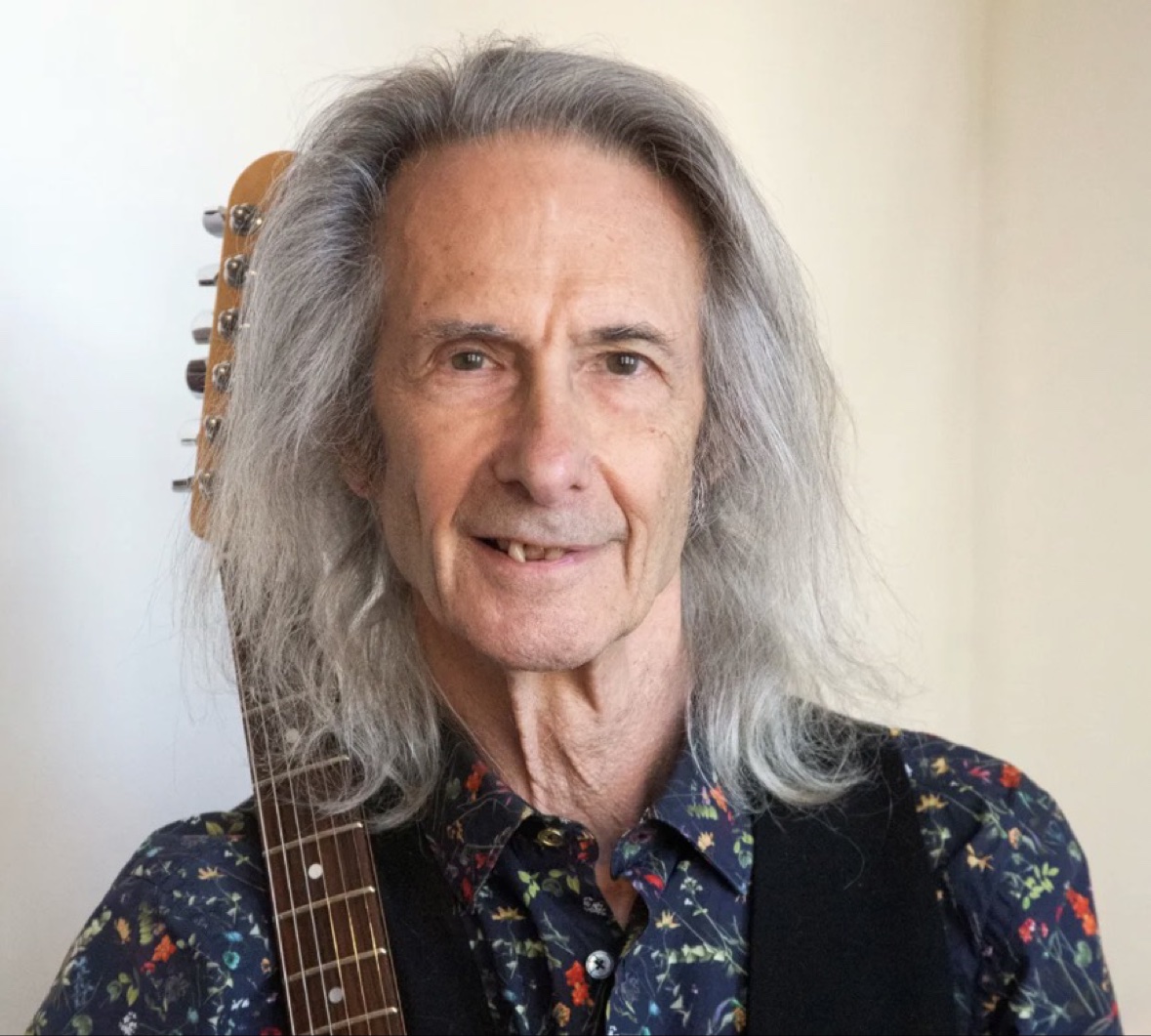 Lenny Kaye today, with long gray hair, holding a guitar